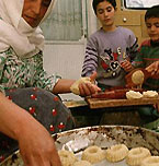 یک زن فلسطینی مسلمان و فرزندانش در ماه مبارک رمضان مسلمانان غذاهای سنتی را در خانه خود تهیه می کنند.